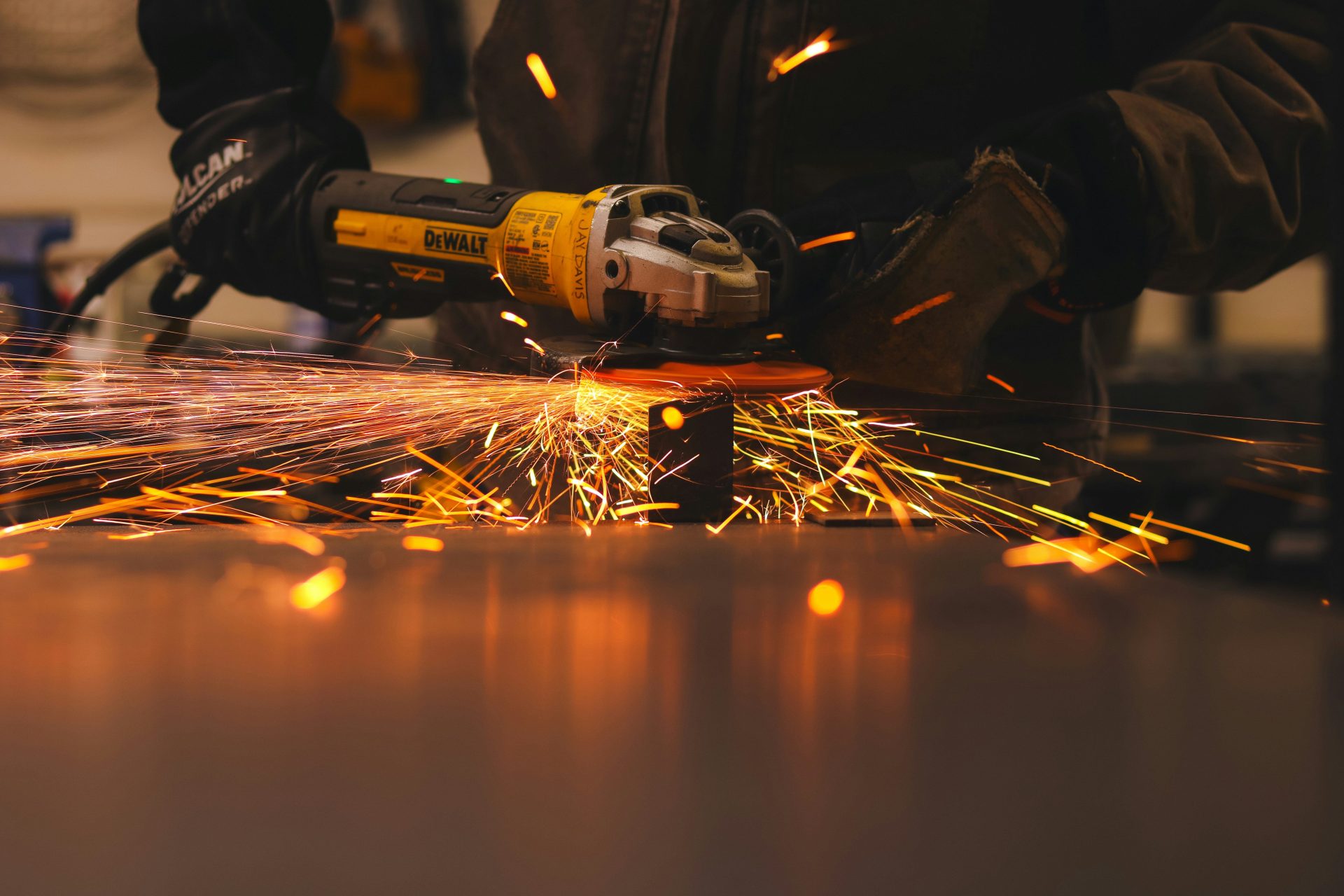 A man working with a grinder on a piece of metal