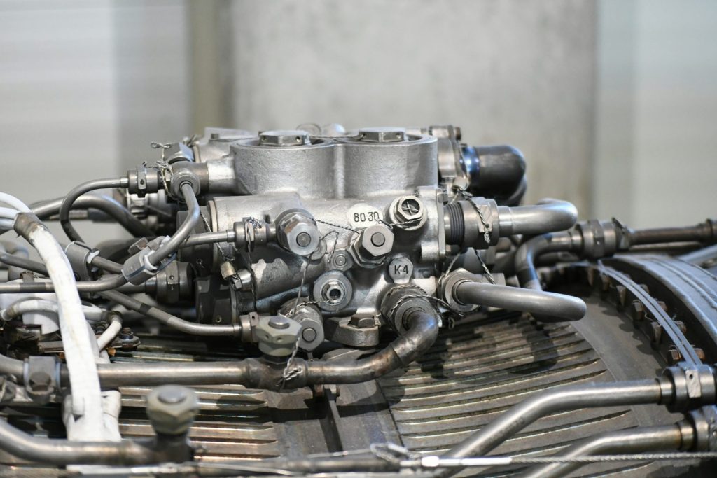 Close-up of a complex engine carburetor system with many tubes.